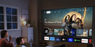 People sitting in a living room looking at a smart TV menu from an Epson Epiqvision Mini EF21 projector