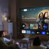 People sitting in a living room looking at a smart TV menu from an Epson Epiqvision Mini EF21 projector