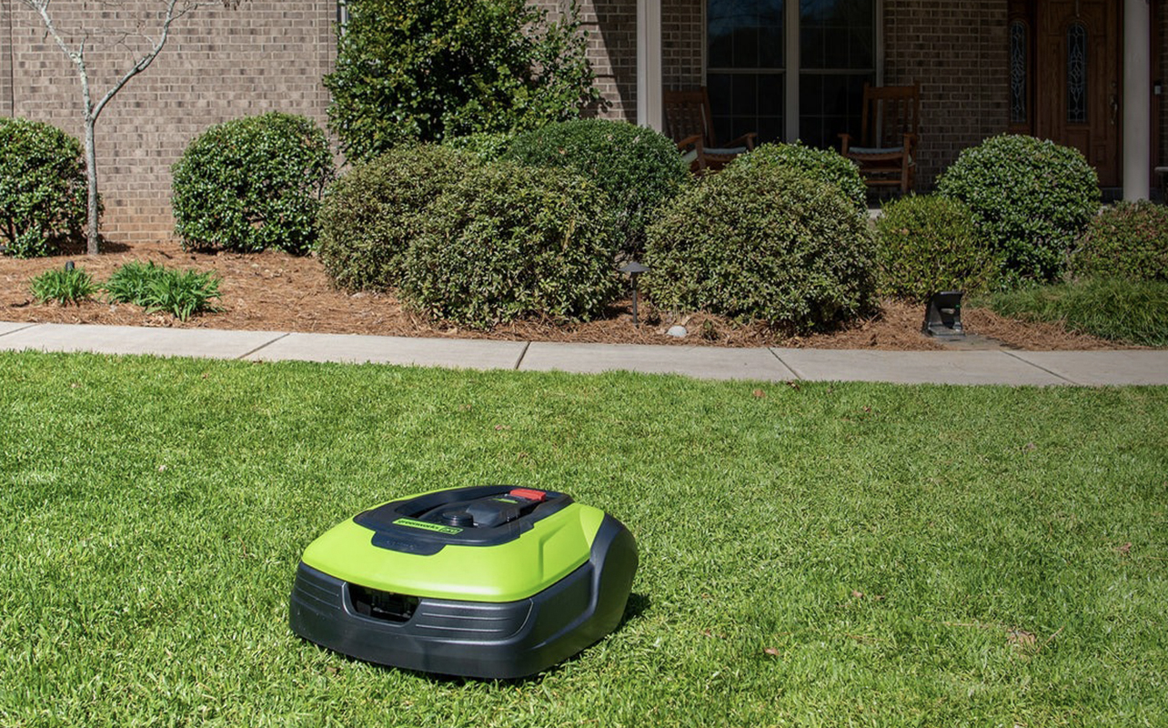 A Greenworks robot lawnmower on a lush green lawn.