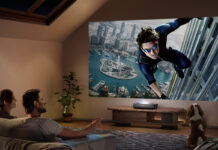 A man and woman watching a large screen from a Hisense PL2 laser projector