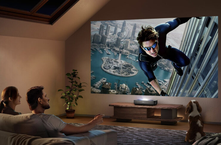 A man and woman watching a large screen from a Hisense PL2 laser projector
