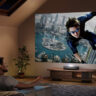 A man and woman watching a large screen from a Hisense PL2 laser projector
