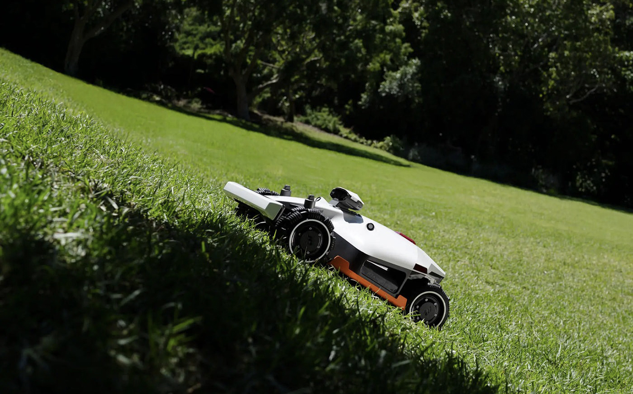 A Luba 2 robot lawnmower going up a sloped lawn.