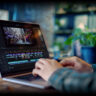 Man editing video on AI laptop.