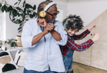 Father and daughter dancing with headphones on