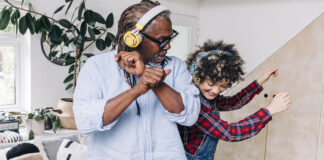 Father and daughter dancing with headphones on