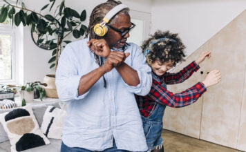 Father and daughter dancing with headphones on