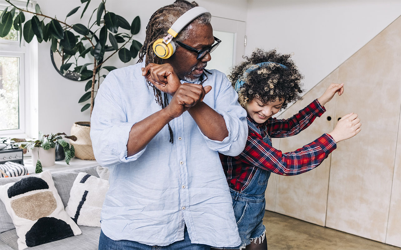 Father and daughter dancing with headphones on