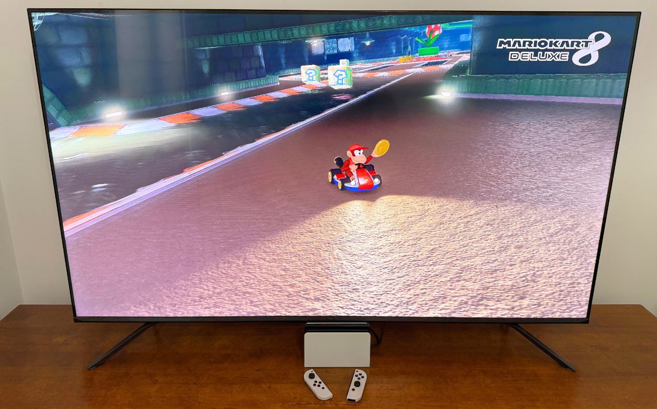 Nintendo Switch in a dock with Mario Kart 8 Deluxe displayed on screen.