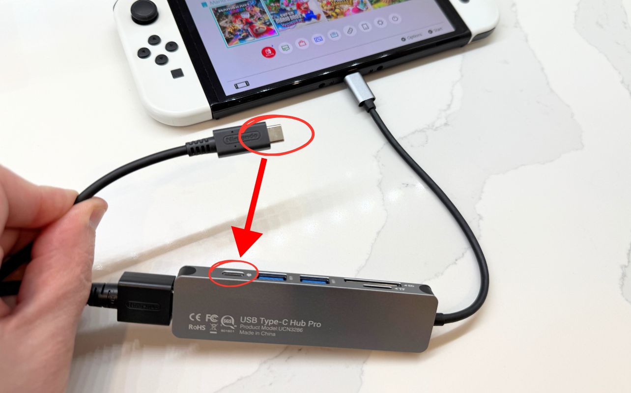 The Nintendo Switch console's third-party hub is connected to an AC adaptor.