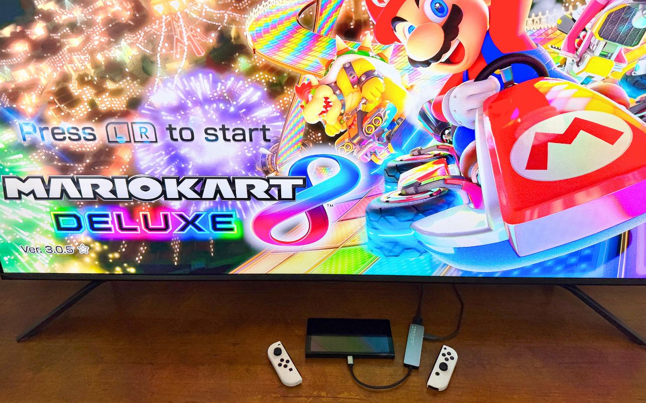 The Nintendo Switch console is attached to a third-party hub operating with Mario Kart 8 Deluxe on the screen.
