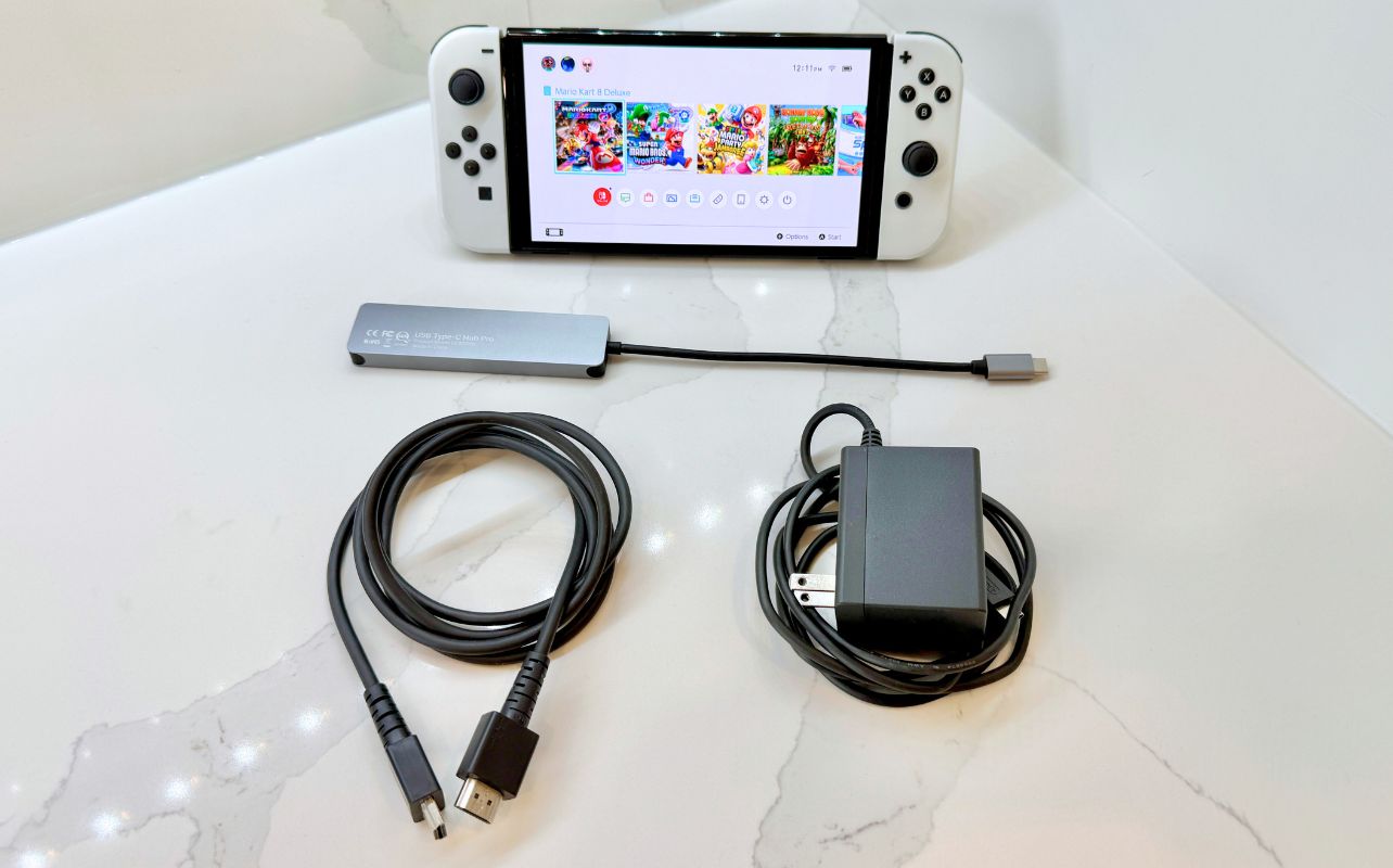 The Nintendo Switch console laid out with a USB-C/HDMI adaptor, HDMI cable and a AC power adaptor.