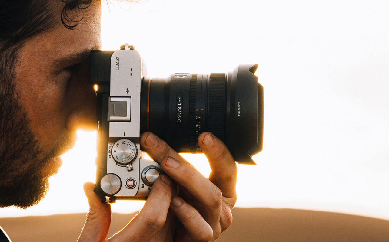 Man taking photo on Sony camera with wide-angle lens.