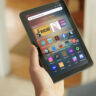 A hand holding an Amazon Fire tablet