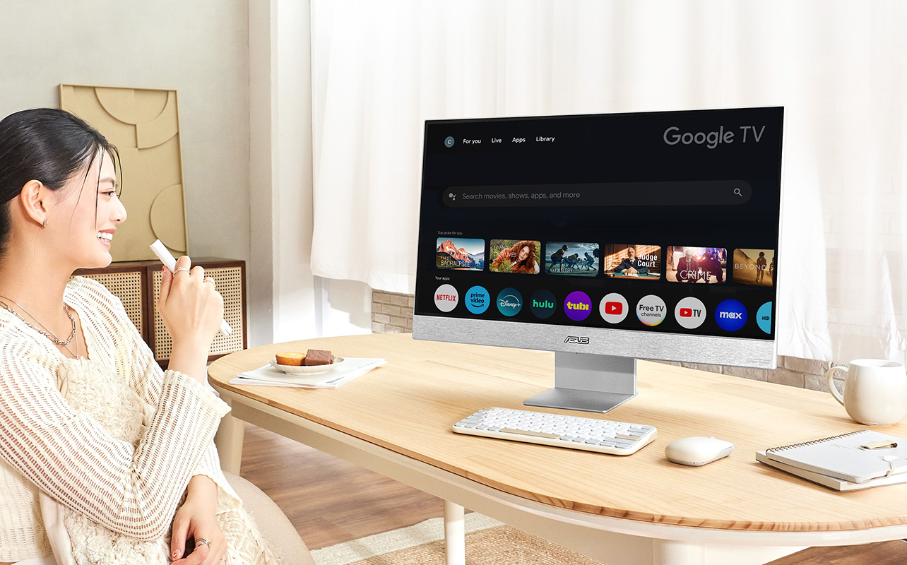 A woman talking into a remote while sitting with an ASUS Zenscreen smart monitor on a desk.