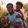 father and son playing baseball in a field. The dad is wearing a Citizen stylish watch.
