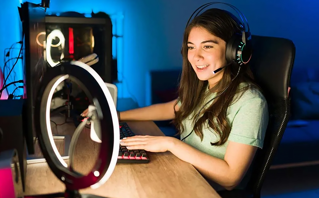 Une jeune femme joue sur une installation PC complète de jeu et de diffusion en continu.