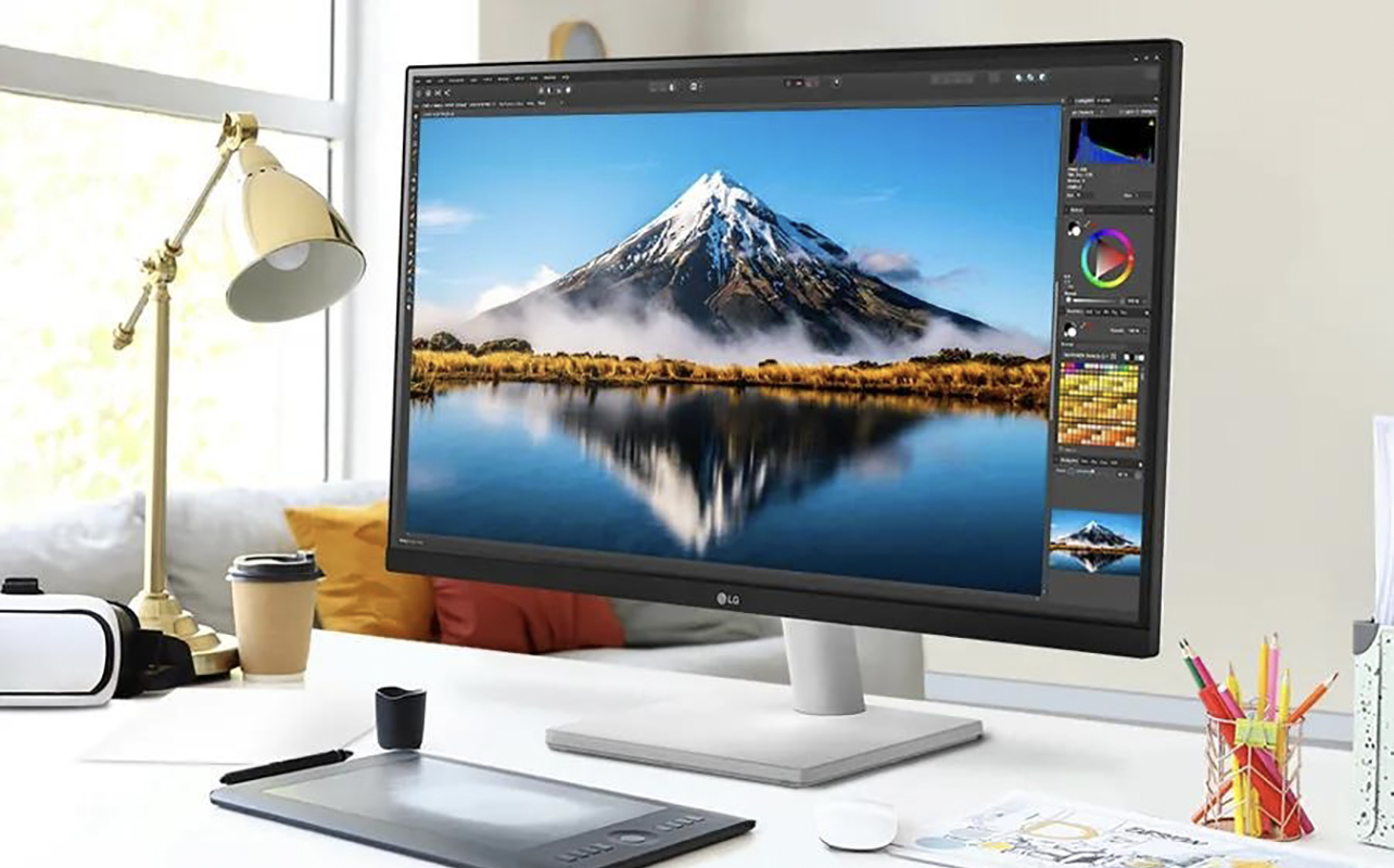 An LG UltraFine 27-inch monitor on a desk with other accessories.