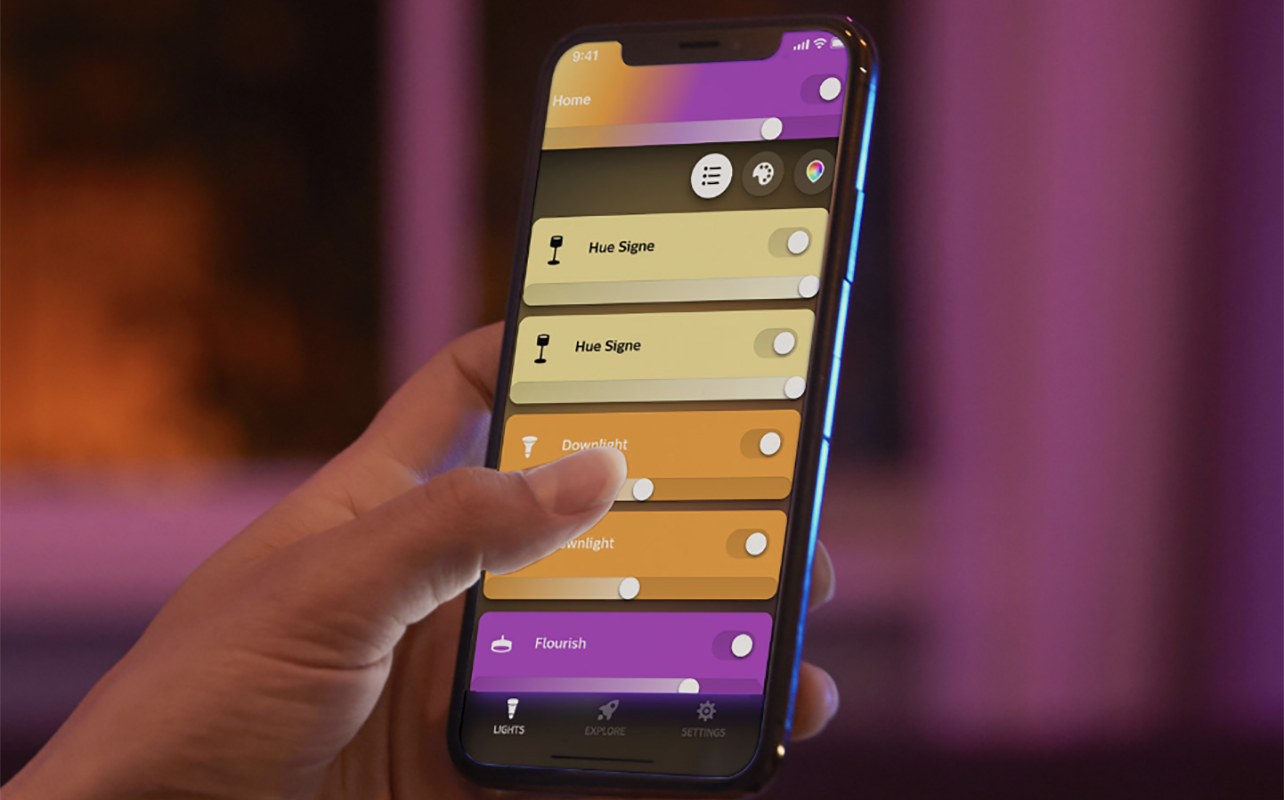 L'application Hue de Philps pour lumières intelligentes sur un téléphone tenu par une main.
