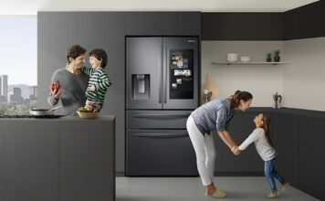 A family in the kitchen with the Samsung Family Hub fridge behind them.