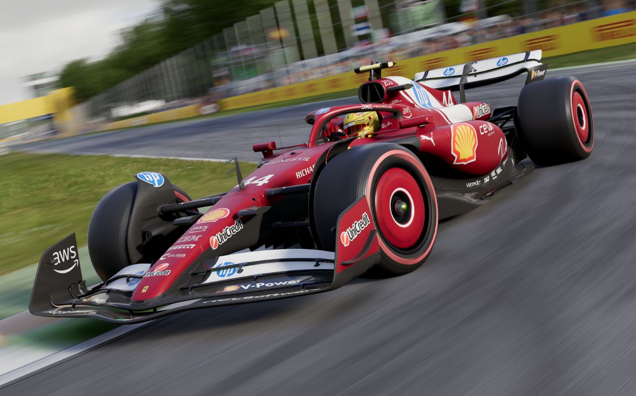 Une capture d'écran dynamique tirée du jeu F1 25, montrant la Ferrari SF-25 de Lewis Hamilton dans un virage à grande vitesse. L'image met en valeur le design élégant et la livrée rouge vif de la voiture, avec un flou de mouvement qui souligne la vitesse intense. On aperçoit également les panneaux jaunes en bordure de piste et la foule floue dans les tribunes.