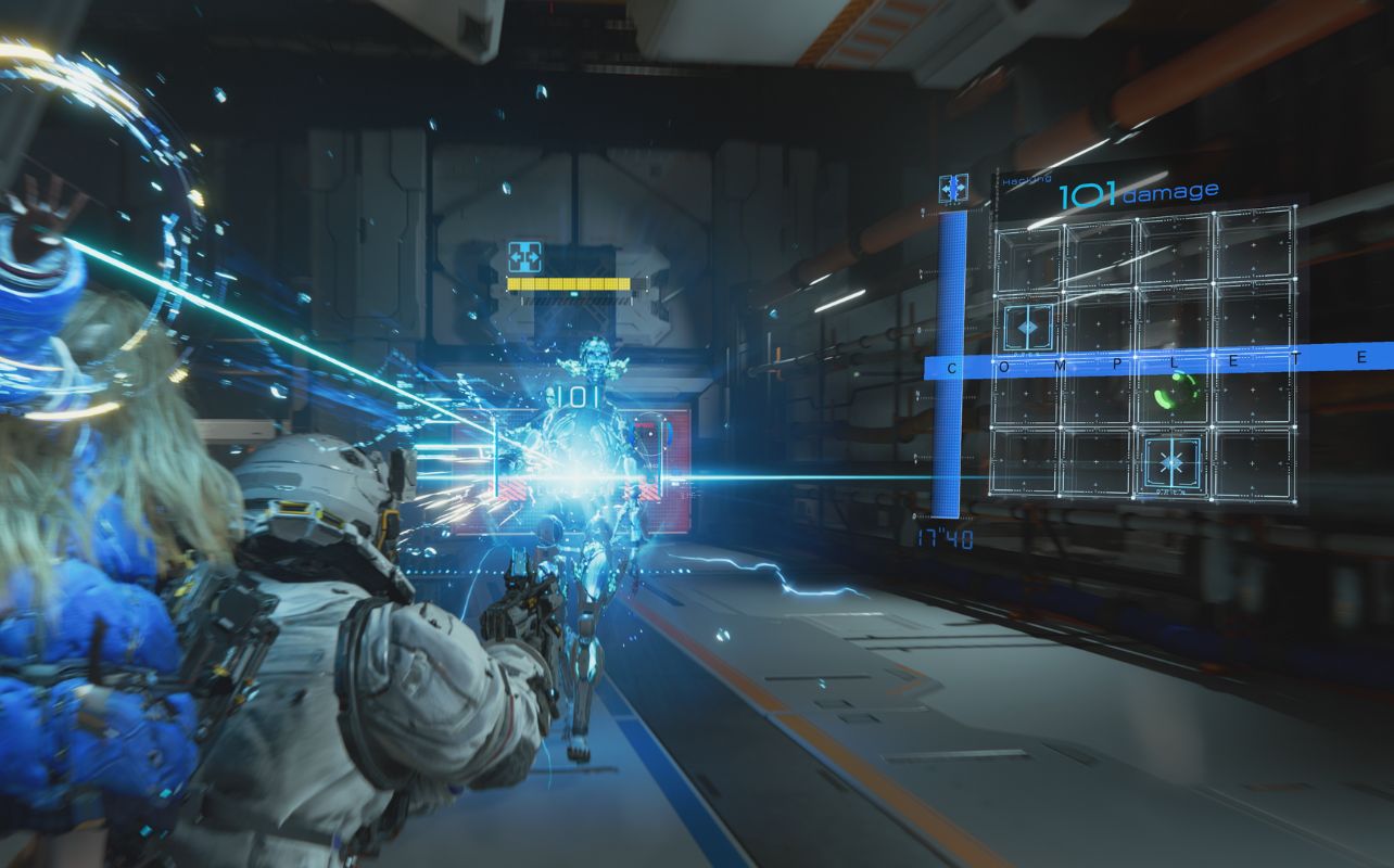 A soldier in armour shoots energy beams at a glowing blue hologram in a futuristic corridor. HUD displays "101 damage" and "COMPLETE."
