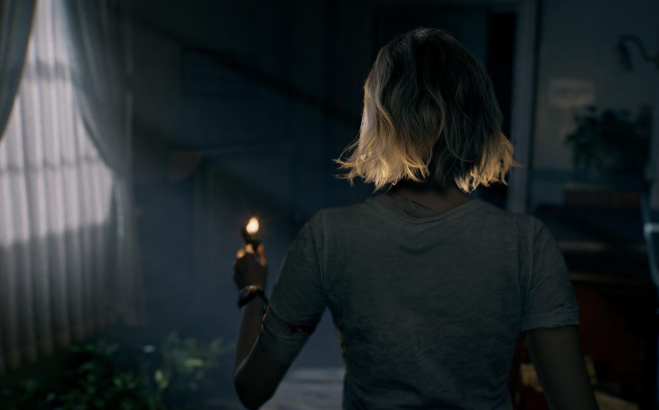 Blonde woman holding a lit match in a dim room with curtains and a plant. Her back is turned, wearing a grey shirt, creating a tense mood.