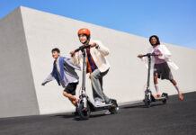 Three kids riding on Segway E3 electric scooters outside.