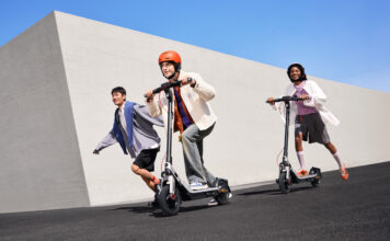 Three kids riding on Segway E3 electric scooters outside.