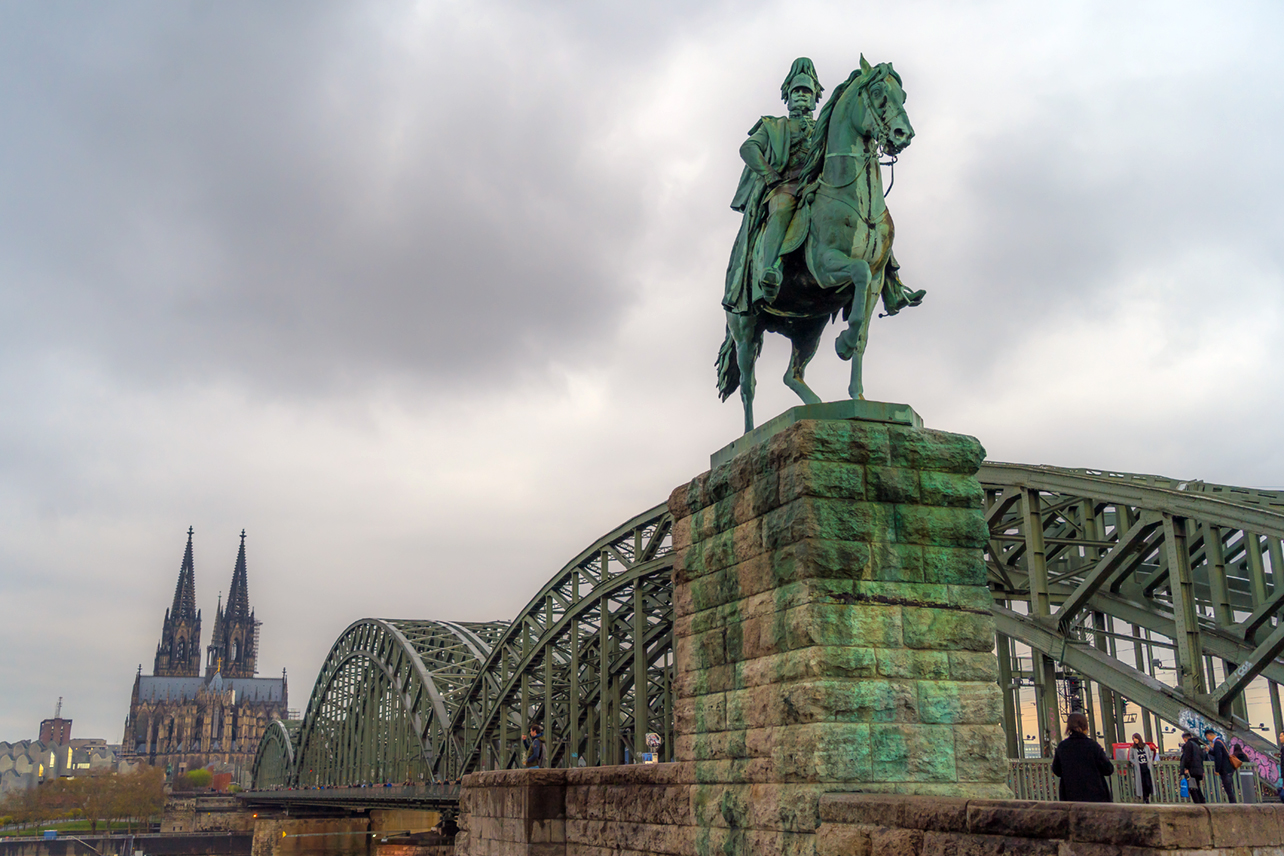 Wide-angle photo of statue with bridge.
