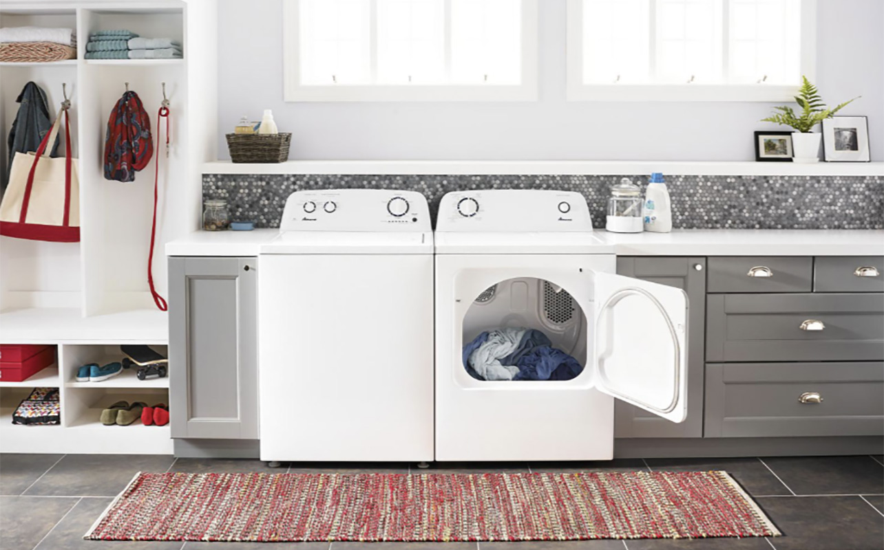 An Amana washer and dryer with the dryer open and clothes inside.