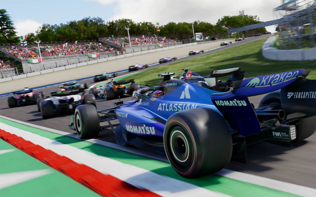Une capture d'écran du jeu F1 25, montrant une voiture de Formule 1 bleue avec des accents rouges, blancs et verts sur la piste, représentant le drapeau italien. La voiture négocie les chicanes à grande vitesse de l'Autodromo Nazionale Monza, entourée de 13 autres concurrents dans une formation très serrée. En arrière-plan, une tribune animée est remplie de spectateurs enthousiastes agitant de nombreux drapeaux italiens.