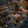 A man looking at the Garmin Instinct Solar 3 on his wrist while camping.