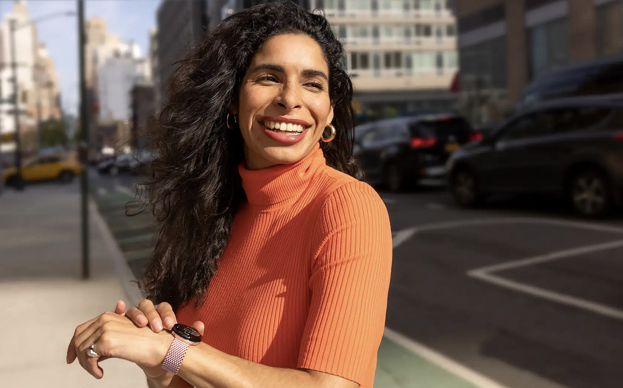 A woman smiling wearing a Google Pixel Watch