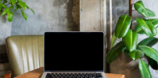 Laptop computer blank screen on table in cafe background. Laptop with blank screen on table of coffee shop blur background