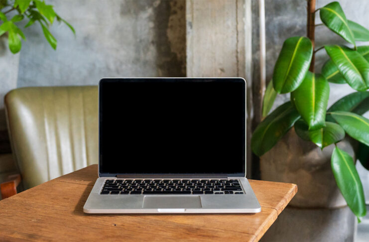 Laptop computer blank screen on table in cafe background. Laptop with blank screen on table of coffee shop blur background