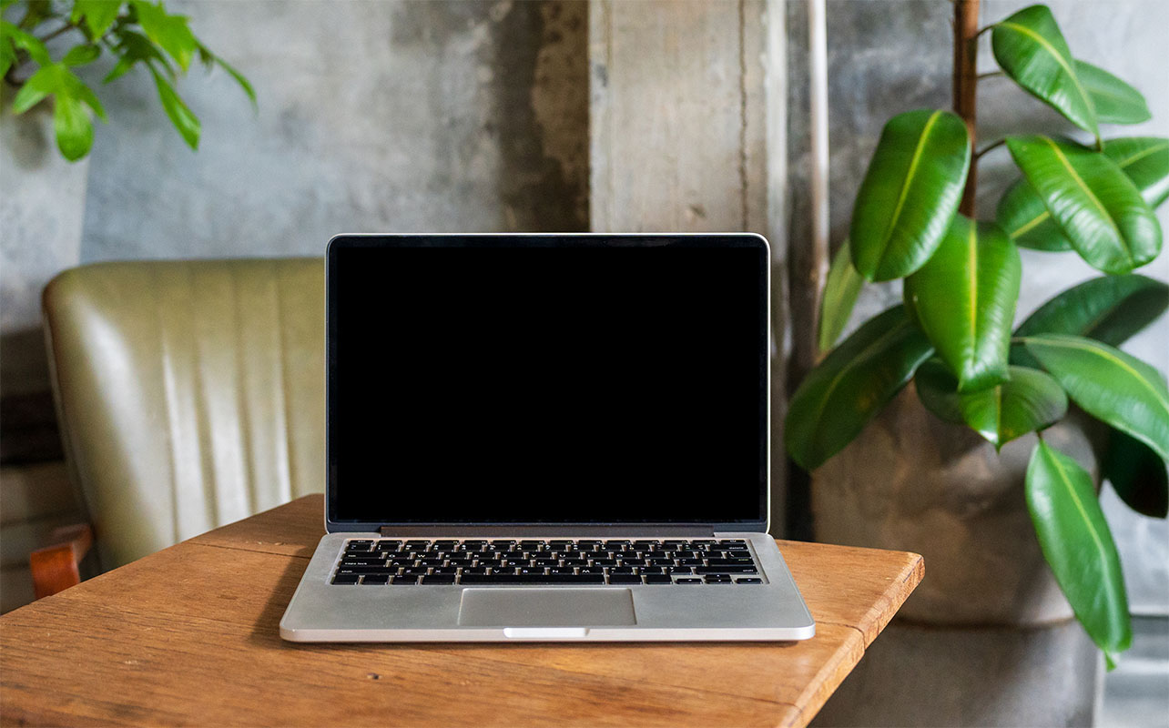 Laptop computer blank screen on table in cafe background. Laptop with blank screen on table of coffee shop blur background