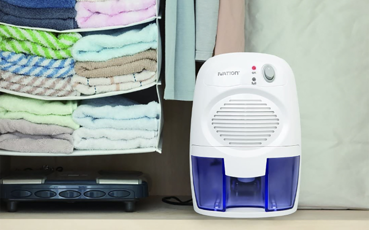 An Ivation dehumifidier beside folded towels.