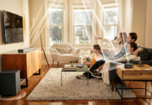 A family watching TV with the JBL Bar 820 9-channel sound bar mounted and lines showing the different channels and how and where they send audio.