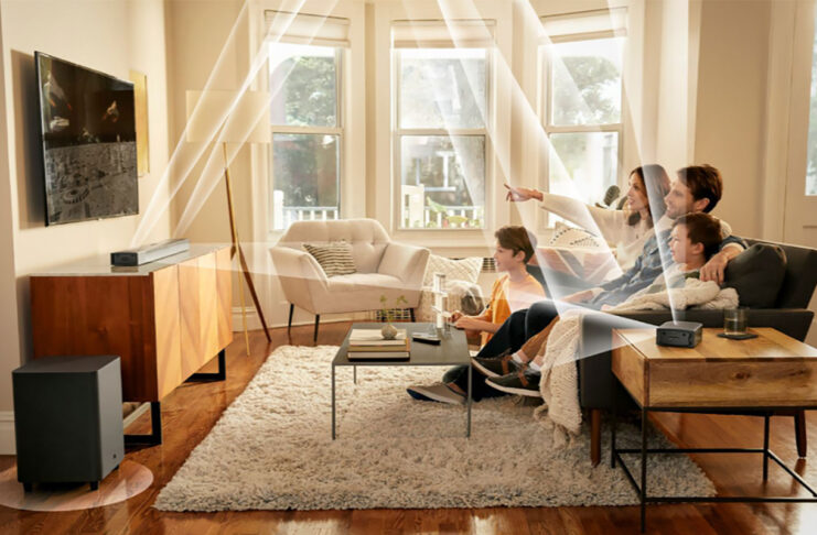 A family watching TV with the JBL Bar 820 9-channel sound bar mounted and lines showing the different channels and how and where they send audio.