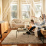 A family watching TV with the JBL Bar 820 9-channel sound bar mounted and lines showing the different channels and how and where they send audio.