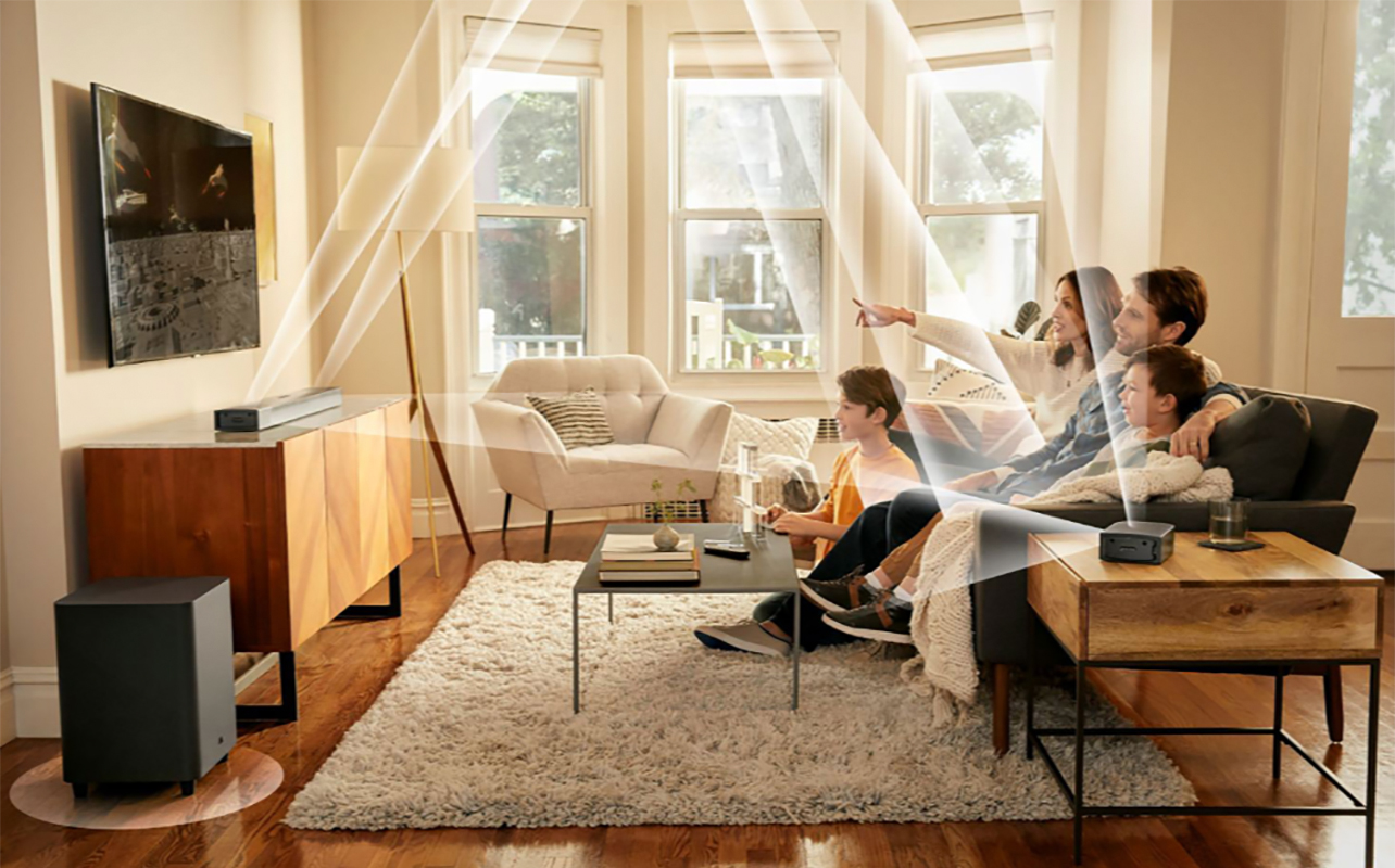 A family watching TV with the JBL Bar 820 9-channel sound bar mounted and lines showing the different channels and how and where they send audio.
