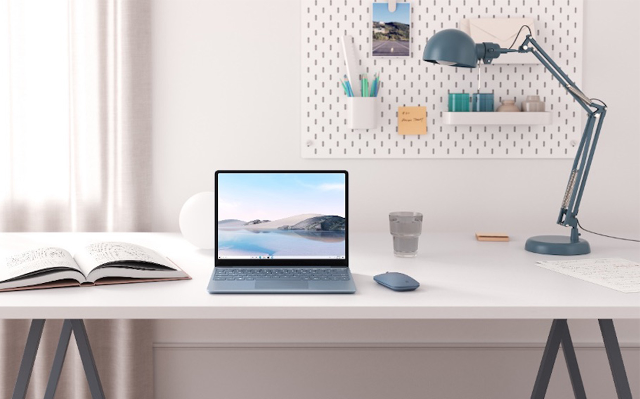 A laptop sits on a neat, well-organized study.