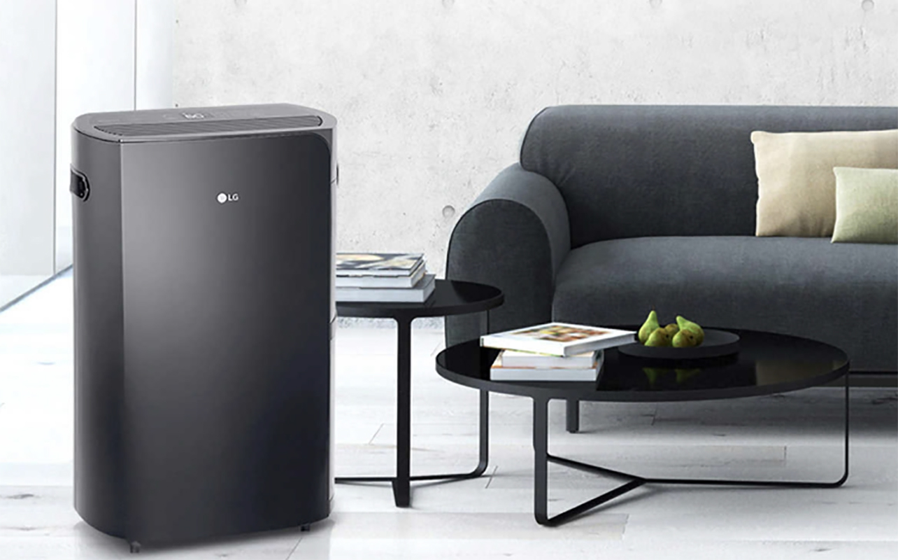 An LG Puricare dehumidifier besude a table and couch.