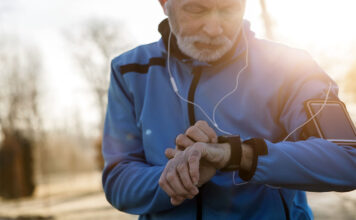 A man looking at a smartwatch on his wrist.
