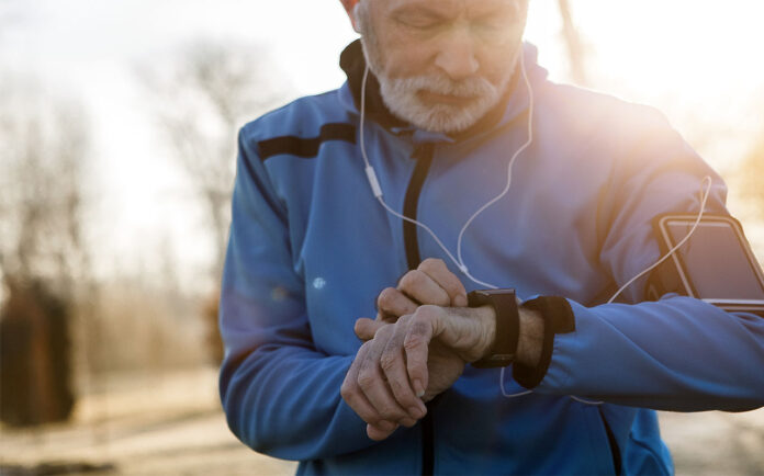 A man looking at a smartwatch on his wrist.