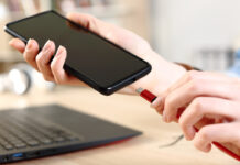 Person plugging in smartphone to charge via USB-C.