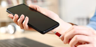 Person plugging in smartphone to charge via USB-C.