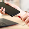 Person plugging in smartphone to charge via USB-C.
