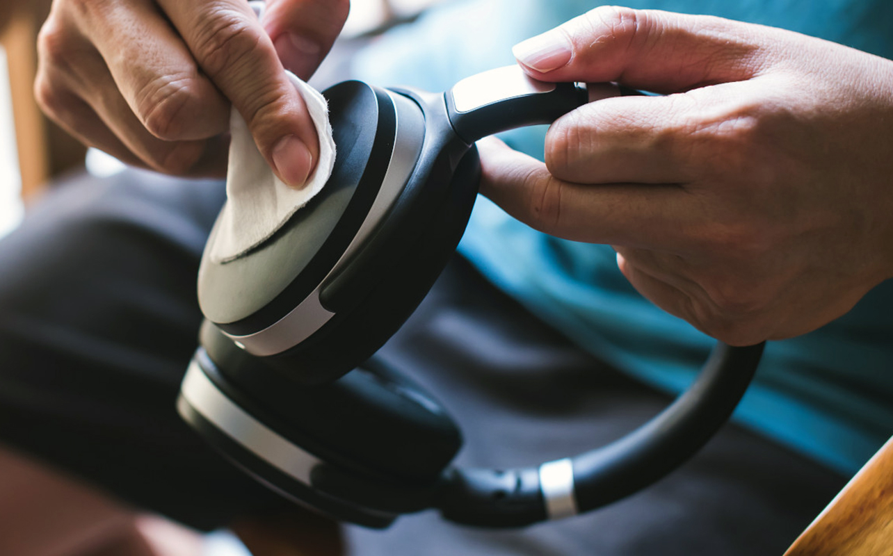 Man cleaning outer ear cup with small microfibre cloth.